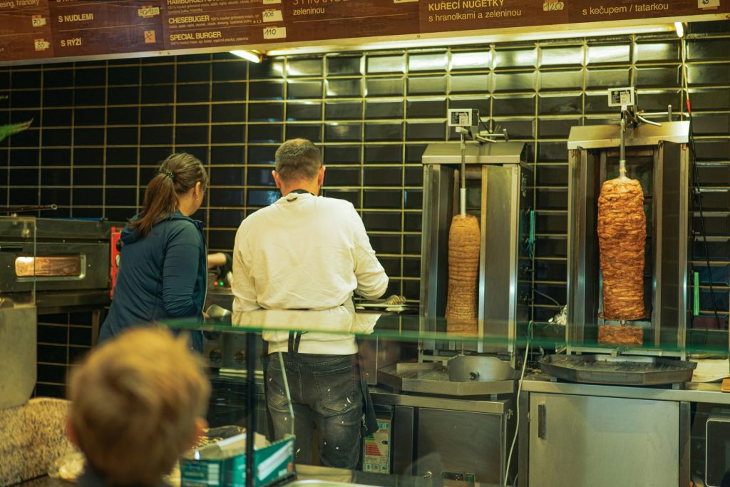 A group of people standing in a kitchen preparing food