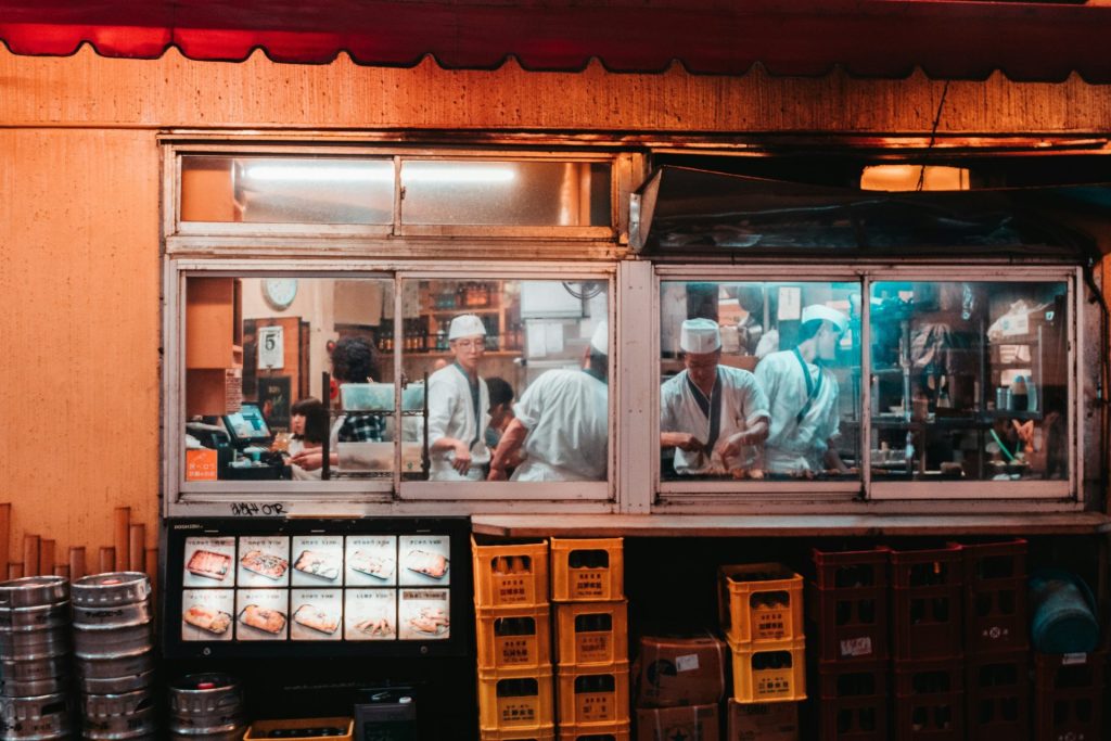 man in white dress shirt standing in front of counter