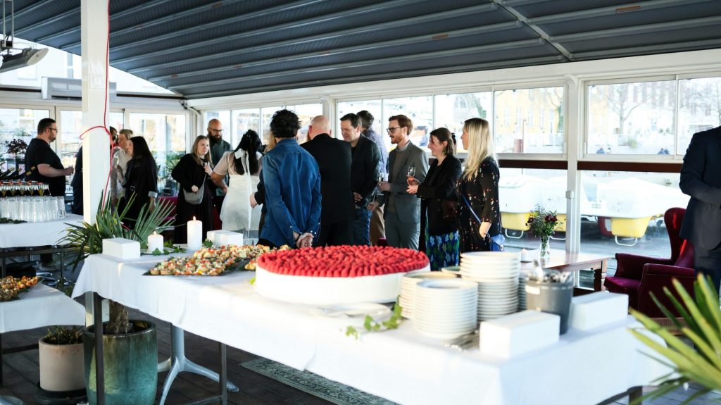 People mingling around a buffet table at an event.